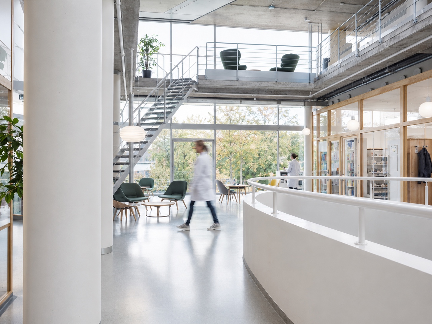 Helles Atrium eines medizinischen Zentrums mit Treppe und Klinikpersonal