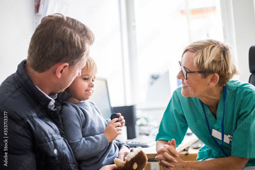 Junger Patient im Rollstuhl mit begleitender Person auf einem hellen Flur